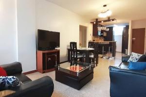 ein Wohnzimmer mit einer Couch, einem Tisch und einem Fernseher in der Unterkunft Moderno y Bonito Apto en Sebucan, Caracas in Caracas