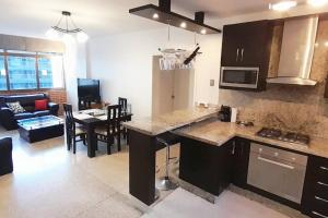 eine Küche und ein Wohnzimmer mit einem Tisch und einer Couch in der Unterkunft Moderno y Bonito Apto en Sebucan, Caracas in Caracas + 25 Fotos