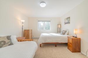 Un dormitorio con dos camas y una ventana. en The Westside Garay Townhome, en Fairbanks