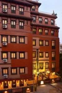 a tall brick building with lights on at Kasthamandap Boutique Hotel in Kathmandu