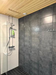 baño con ducha y azulejos grises en Lux home III, en Tampere