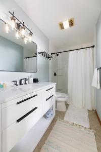a white bathroom with a sink and a mirror at Smokey Hollow's Secret Hot Tub Beach AC in Traverse City +54 photos