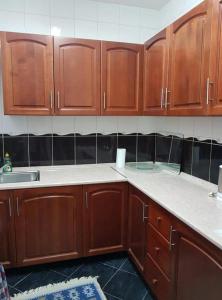 una cucina con armadi in legno e ripiani bianchi di Adnna Home a Bihać Altre 7 foto