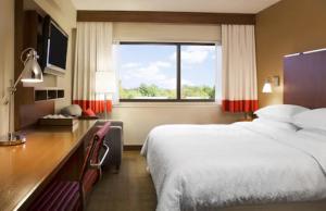 a hotel room with two beds and a desk and a window at Four Points by Sheraton Edmundston Hotel & Conference Center in Edmundston +11 photos