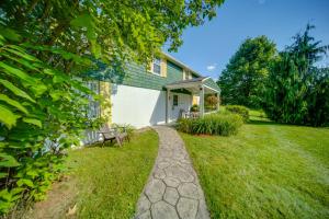 une maison avec un banc et une cour gazonnée dans l'établissement Walk to Chautauqua Lake Mayville Getaway!, à Mayville