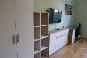 a room with a desk with a computer and a television at Monica's Apartman in Szeged