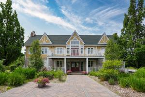 ein großes gelbes Haus mit einer Veranda in der Unterkunft King Bed, Balcony, Pool, Hot Tub, Sauna in Edgar