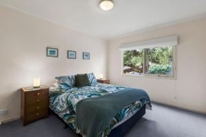 un dormitorio con una cama y una ventana en Lonsdale Back Beach Retreat, en Point Lonsdale