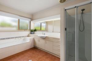 un baño con lavabo y ducha en Lonsdale Back Beach Retreat, en Point Lonsdale 5 fotos más