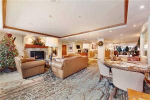 a large living room with a christmas tree in it at Ski In, Ski Out Studio Condo In The Heart Of Lionshead Village With Hot Tub And Pool Access in Vail