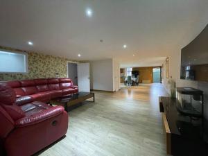 a living room with a red couch and a television at Sunshine three bedrooms Apartment in Insch