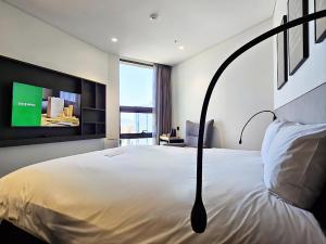 a bedroom with a bed with a tv on the wall at GLAD Gangnam COEX Center in Seoul