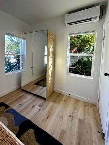 ein leeres Zimmer mit einem Spiegel und zwei Fenstern in der Unterkunft Modern, Remodeled Echo Park House-Walk to Sunset Blvd, Dodgers Stadium, Shops, Bars, Restaurants, Lake, Concerts in Los Angeles + 16 Fotos
