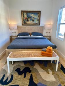 Schlafzimmer mit einem Bett mit blauer Tagesdecke und einem Teppich in der Unterkunft Modern, Remodeled Echo Park House-Walk to Sunset Blvd, Dodgers Stadium, Shops, Bars, Restaurants, Lake, Concerts in Los Angeles