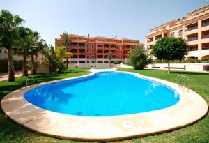 a large swimming pool in front of a building at Las Flores Apartment in Denia