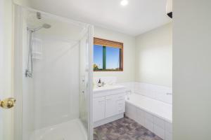 a white bathroom with a tub and a sink at Great Location, Affordable, Units in Kaikoura +12 photos