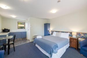 a hotel room with a bed and a desk and a table at Great Location, Affordable, Units in Kaikoura