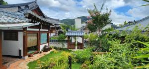 a garden in front of a house with a building at Jahayeon Hanokstay in Jeonju