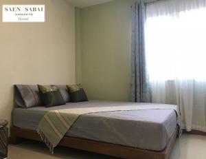 莱卡邦Saen Sabai Hostel的卧室里有一张床，窗户很大