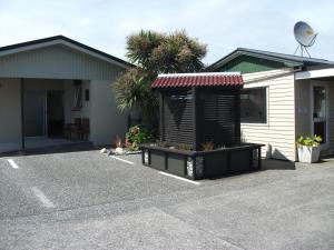 a house with a parking lot with a garage at Scenicland Motels in Greymouth
