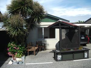 a backyard with a shed and a table and chairs at Scenicland Motels in Greymouth