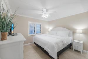 ein weißes Schlafzimmer mit einem Bett und einem Deckenventilator in der Unterkunft Waterfront Island Oasis! Heated Pool with Stunning View & 2 Full Bath in Marco Island