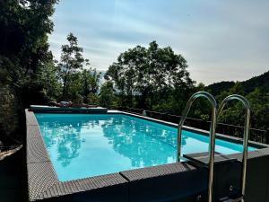 a large blue swimming pool with metal bars around it at L'hotelet d'Estamariu Cal Teixidor in Estamariu
