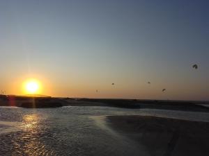 a group of kites flying over the ocean at sunset at Casas Bennu Preá in Prea