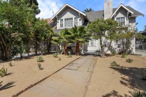 a house with palm trees in front of it at Spacious Chic 5 Bedroom Perfect for Large Group With parking in Los Angeles