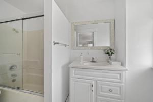 a white bathroom with a sink and a shower at Spacious Chic 5 Bedroom Perfect for Large Group With parking in Los Angeles +11 photos