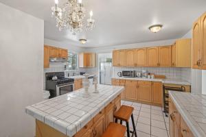a large kitchen with wooden cabinets and a chandelier at Spacious Chic 5 Bedroom Perfect for Large Group With parking in Los Angeles