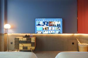 A television and/or entertainment centre at Sandstone Painting Handicraft Exchange Gallery Hotel