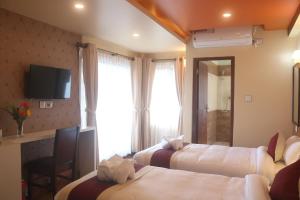 a hotel room with two beds and a television at Hotel Family Ties Pvt. Ltd. in Kathmandu
