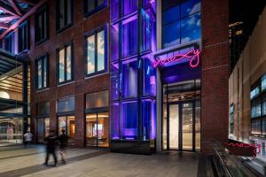 people walking in front of a building with purple lights at Moxy Bangkok Ratchaprasong in Bangkok