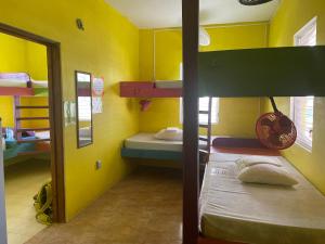 a room with two bunk beds and a mirror at Travellers Palm Backpackers in Caye Caulker