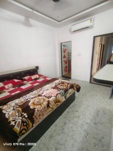 a bedroom with a bed with a floral bedspread at Guest house Khatu Shyam Ji in Khātu