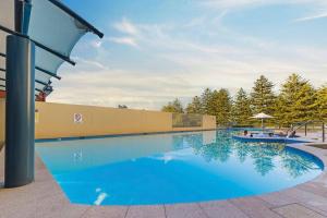 a large blue pool with a boat in it at Ocean View Private Cronulla Apartment in Cronulla