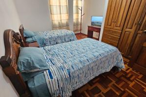 a bedroom with a bed and a dresser and a television at Lindo Departamento a estrenar in Latacunga