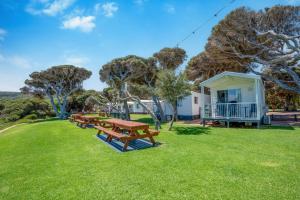 a picnic table in the grass in front of a cabin at Tasman Holiday Parks - Yallingup Beach in Yallingup