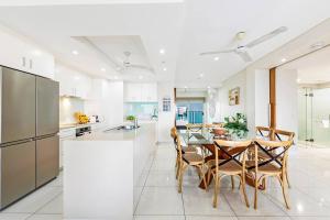 达尔文Skytower Wonder Ocean View Balcony - Pool - Office的配有桌椅的厨房和餐厅