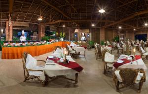 a restaurant with white tables and chairs and a counter at Soma Manaltheeram Ayurveda BeachVillage in Kovalam