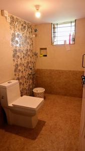 a bathroom with a white toilet and a shower at Ashiana Farms in Andevanahalli