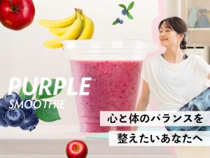 石垣岛The BREAKFAST HOTEL MARCHE Ishigaki Island的站在水果和蔬菜的冰沙旁的女人