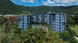 an aerial view of a building with mountains in the background at Modern Condo in Boutique Style Resort CGB4 in Phuket Town