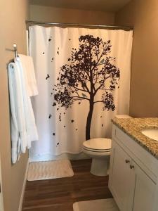 a bathroom with a shower curtain with a tree at 3Bed 2Bath Spacious-LakeHomeAceLoc4milesLEGOLAND in Cypress Gardens