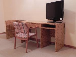 a computer desk with a television and a chair at Toros de Guisando in El Tiemblo