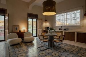 a living room with a table and chairs and a kitchen at Narrativ Lofts in Campeche