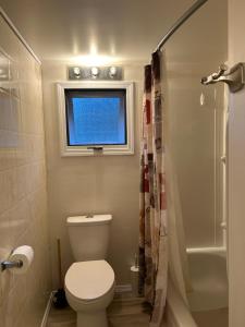 Un pequeño baño con inodoro y ventana. en Waterfront, Mountainview House in Castlegar, en Castlegar 25 fotos más