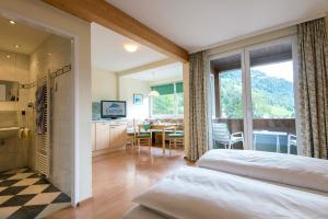 ein Schlafzimmer mit einem Bett und eine Küche mit einem Tisch in der Unterkunft Haus Friedrichsburg - Bergbahnen bis November inklusive in Bad Hofgastein