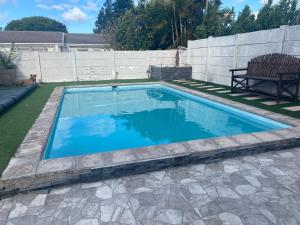 a swimming pool with blue water in a backyard at 5 AntiP in Cape Town